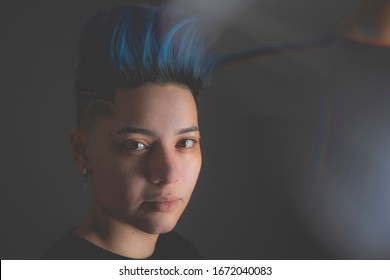 Portrait Of Lesbian Punk Woman With Blue Mohawk Hairdo. Punk Feminist Female With Sad Expression. Millennial Gender Search Of Sexual Identity. Lgbt Concept And Gay Pride. Diverse Homosexual People.