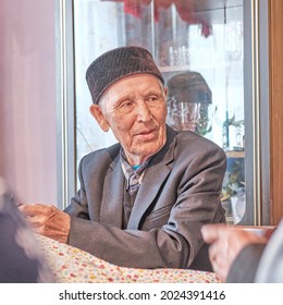 Portrait Of Listening Carefully Asian Senior Muslim Man Sitting At Table At Home