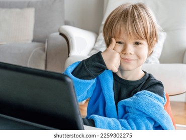 Portrait of little 4 years old boy sitting on living room and using digital tablet computer with thumb up. - Powered by Shutterstock