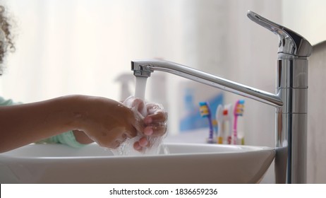 Portrait Of Little African-american Girl Washing Hands In Bathroom. Close Up Of Adorable Black Kid Cleaning Hands In Sink At Home Bathroom Or In Kindergarten