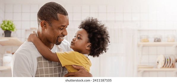 Portrait of little American African black boy parent cooking preparing food with pan in the counter kitchen. Happy  family with father son, father's day, healthcare cooking plant based food concept - Powered by Shutterstock