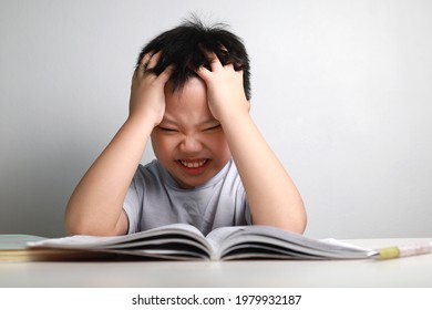 Portrait Of Little Asian Boy Bored, Frustrated And Fed Up Doing His Homework