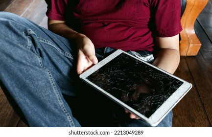 Portrait Of A Little Asian Boy, Kid Sad Face, Unhappy Child Sitting Holding  Broken Tablet Computer, Emotion Sad And Sad Face, Depressed Children Concept