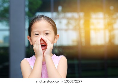 Portrait Little Asian Child Girl Acting And Shouting Through Hands Like Megaphone. Communication Concept.