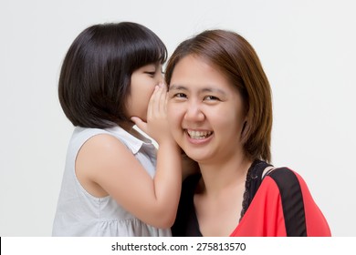 Portrait Of Little Asian Child Whispering To Her Mother