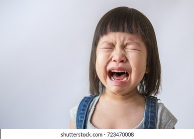 Portrait of little asian crying girl little rolling tears weeping emotion hurt pain fit drops cheek. Young asian toddler girl in her terrible two.