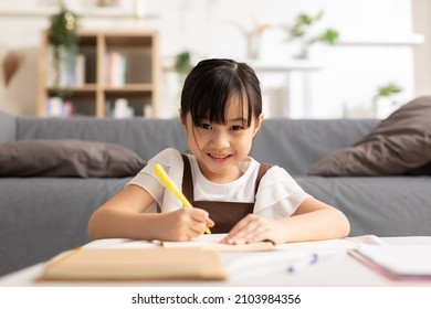 Portrait of little Asian girl child study learn at home smile and happiness.Cute girl drawing and handwriting in notebook to develop her skill and Emotional Quotient.Home School Education Concept - Powered by Shutterstock