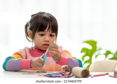 Portrait of a little asian girl cutting a paper in activities on DIY class at School.Scissors cut paper. - Shutterstock ID 2174403799