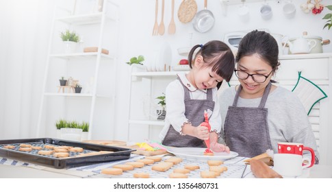Portrait Of Little Asian Girl And Mother Baking Cooking Decorate Cake And Cookies In The Kitchen. Happy Asian Family Love Together Parenthood Food Nutrition Asia Mother’s Day Concept Banner