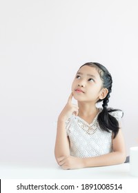 Portrait little Asian girl sitting thinking something and smile with happiness select focus shallow depth of field with copy space - Shutterstock ID 1891008514