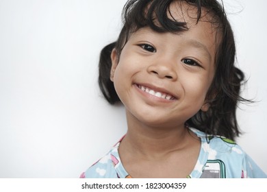 Portrait little Asian girl smiling with a good mood and white background (real people and real bodies concept)