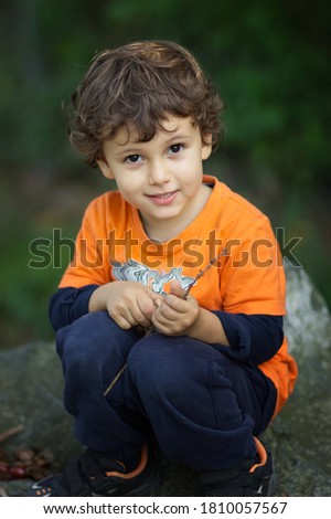 Cute little boy seated on the wall of a castle