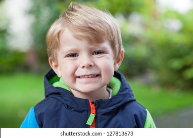 Portrait Of Little Blond Toddler Boy Smiling Outdoors, Summer.