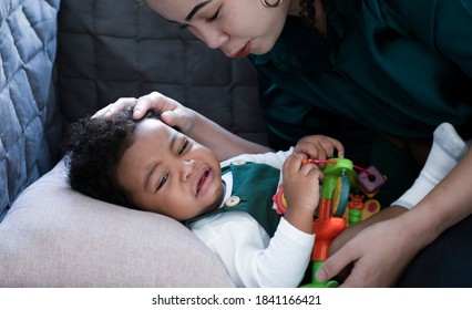 Portrait A Little Boy African American Newborns Crying On A Bed While Mother Consoled And Support As Her Son Cried. Inconsolable Cry Infant Mother Console Newborn. Family Concept.