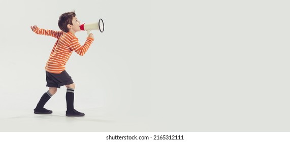 Portrait Of Little Boy, Child Shouting In Megaphone, Playing Isolated Over Grey Studio Background. Concept Of Childhood, Friendship, Family, Fun, Lifestyle, Retro Fashion. Copy Space For Ad. Flyer