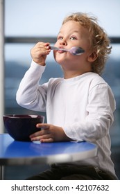 Portrait Of The Little Boy Eating Yogurt.