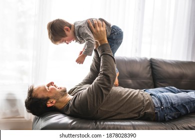 A Portrait of little boy with father having fun on sofa