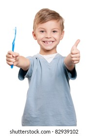 Portrait Of A Little Boy Holding A Tooth Brush Over White Background