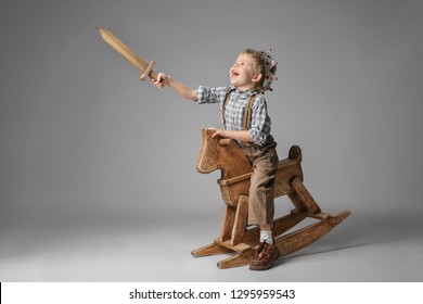 Porträt eines kleinen Jungen in einer Ritterkostüme auf einem rockigen Pferd