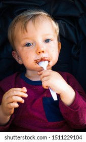 Portrait Of Little Boy Licking Chocolate Covered Spoon