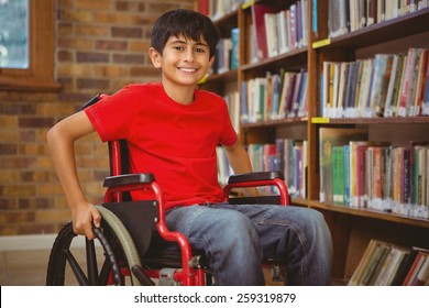 Portrait of little boy sitting in wheelchair at the library