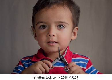 Portrait Of Little Boy Using Pliers