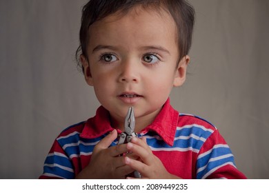 Portrait Of Little Boy Using Pliers