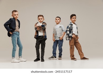 Portrait of little boys, friends posing in trendy clothes showing confidence and style against grey studio background. Concept of childhood, kid's fashion and beauty, school shopping. Black Friday - Powered by Shutterstock