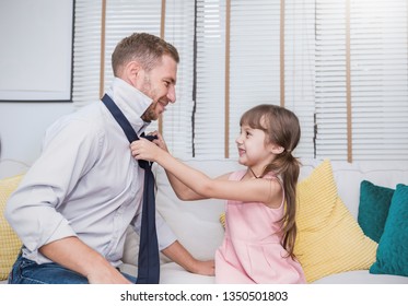 Portrait Of Little Caucasian Girl Helping Her Father Tie Necktie In The Living Room. Daddy And Toddler Daughter Get Ready To Work In The Morning. Love Family Lifestyle Together, Father’s Day Concept