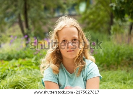 Portrait of a little cheerful girl in a striped T-shirt. Outdoor.