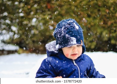 Portrait Of Little Child With Atopic Eczema On Cheeks At Winter Outdoors. Seasonal Cold Allergic Rash On Baby Skin. Snowing, Outside, Walk