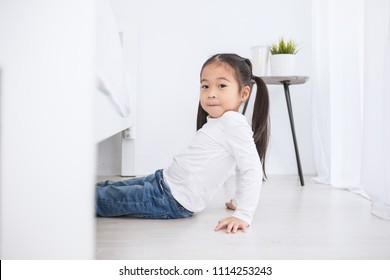 Portrait of little cute asian girl hiding behind under the bed in the morning in white bedroom. Hind and seek fun play toddler early childhood education home school concept. - Powered by Shutterstock