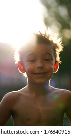 Portrait Of Little Cute Boy Shirtless On Playground. Backlit Child Smiling