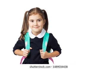 Portrait of a little cute girl with a backpack in the school uniform going to school. Copy space. Isolated on the white background. The concept of education, back to school, etc.