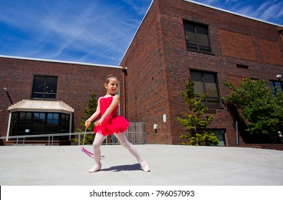 Portrait Of Little Cute Girl In Bright Pink Leotard Perform Making New Ballet Movement With Wang At Outdoor Stage In Downtown Vancouver WA USA At Hot Summer Day