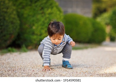 Side View Of Cute Baby Boy Looking Away While Standing On Dirt Stock Photo