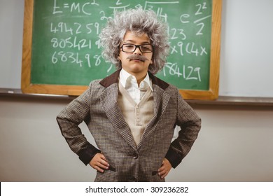 Portrait Of Little Einstein Posing In Front Of Chalkboard In A Classroom