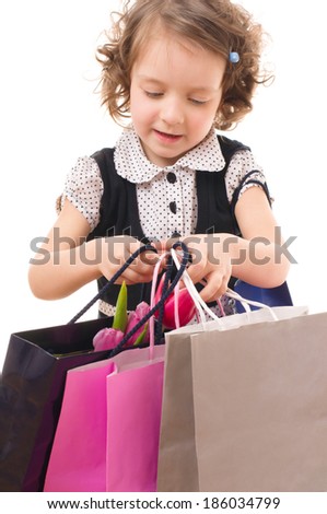 Portrait of a little fashion shopping girl with shopping bags, isolated over white