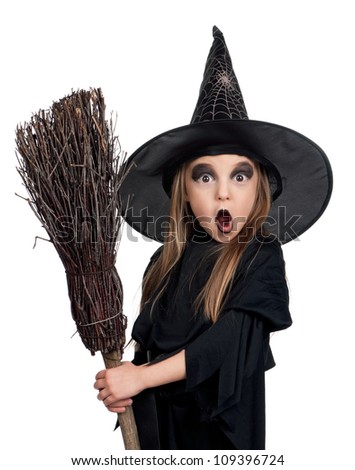 Portrait of little girl in black hat and black clothing with broom on white background