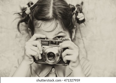 Portrait of a little girl with camera/ vintage/ sepia,/old photo/filter