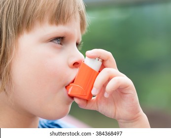 Portrait Of Little Girl Child Using Asthma Inhaler Outdoors