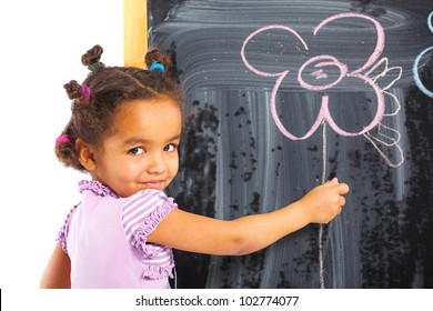 Portrait of little girl is drawing on a blackboard. Isolated on white background