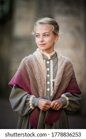 Portrait of a little girl dressed in vintage style. Long dress in the style of the nineteenth century, knitted shawl on the shoulders.