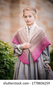 Portrait Of A Little Girl Dressed In Vintage Style. Long Dress In The Style Of The Nineteenth Century, Knitted Shawl On The Shoulders.