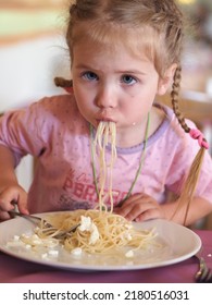 Portrait Of A Little Girl Eating Spaghetti With A Fork