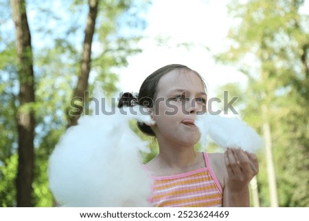 Similar – Image, Stock Photo Girl plucks off a piece of cotton candy