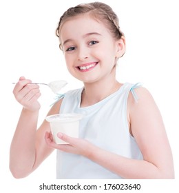 Portrait of a little girl eating yogurt - isolated on white.