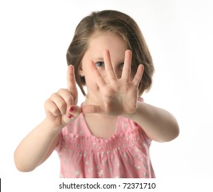 Portrait Of A Little Girl Holding Up Six Fingers In Front Of Her Face To Show Hold Old She Is, Isolated On White