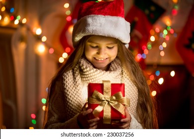 Portrait Of Little Girl Looking At Open Box With Christmas Present