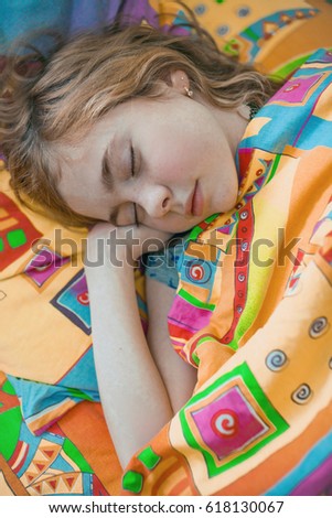Portrait of little girl lying in her bed